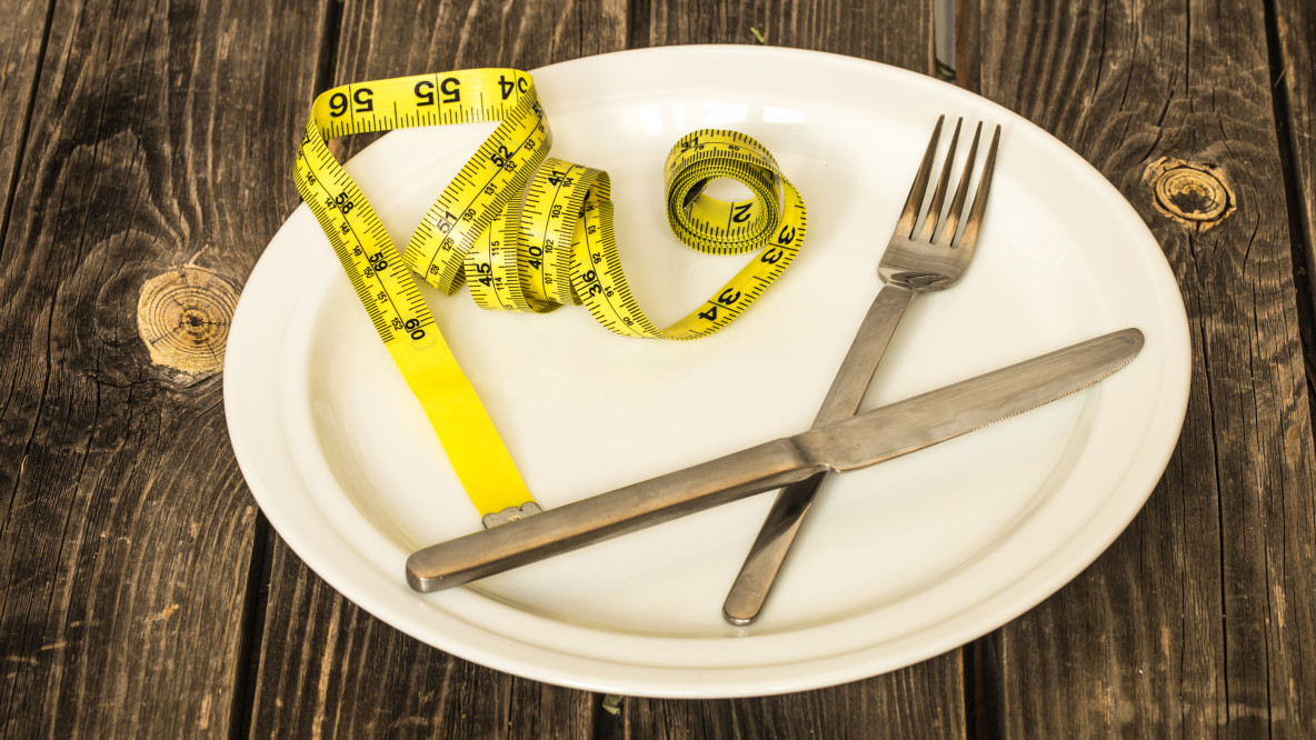 white-plate-with-bun-yellow-tape-measure-and-cutlery-on-table.jpg